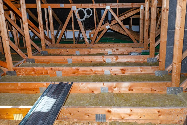 Ceiling and attic floor insulation made of rock wool between the trusses, visible system chimney.