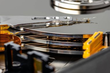 Bir sabit diskteki manyetik iğnenin makro fotoğrafı, üç plakalı açık bir HDD.
