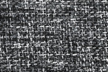 Yatay ve dikey çizgilerle örülmüş beyaz ve siyah bir kumaşın makro görüntüsü.