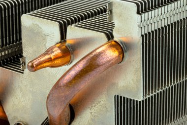 Görünür bakır ısı dağıtım tüpleri olan bir bilgisayardan alüminyum ısı alıcısının makro fotoğrafı..