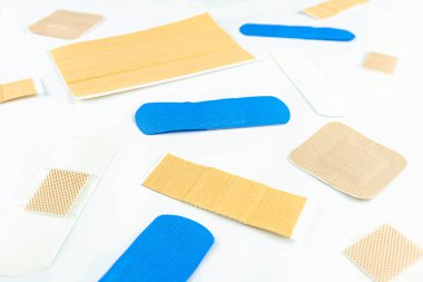 Farklı yara bantlarından oluşan arkaplan, üst görünüm, seçici odak, beyaz arkaplanda izole edilmiş.