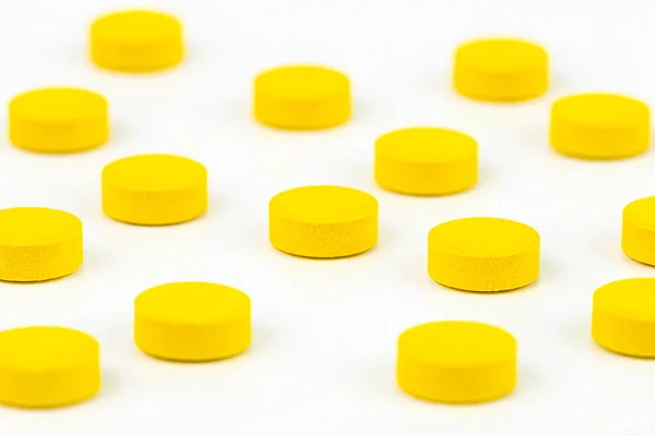 Sárga Tabletták Makrofelvétele Véletlenszerűen Elrendezve Fehér Alapon Elkülönítve — Stock Fotó