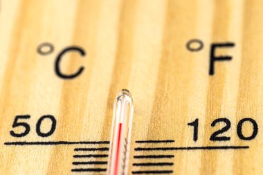 Klasik bir ahşap termometrenin makro çekimi 50 derecenin üzerinde sıcaklık gösteriyor, 122 Fahrenheit derece..