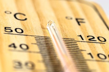 Klasik bir ahşap termometrenin makro çekimi 50 derecenin üzerinde sıcaklık gösteriyor, 122 Fahrenheit derece..