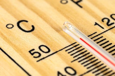 Klasik bir ahşap termometrenin makro çekimi 50 derecenin üzerinde sıcaklık gösteriyor, 122 Fahrenheit derece..
