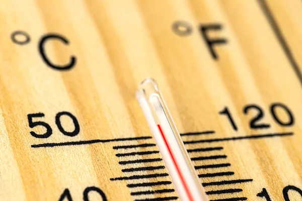Klasik bir ahşap termometrenin makro çekimi 50 derecenin üzerinde sıcaklık gösteriyor, 122 Fahrenheit derece..