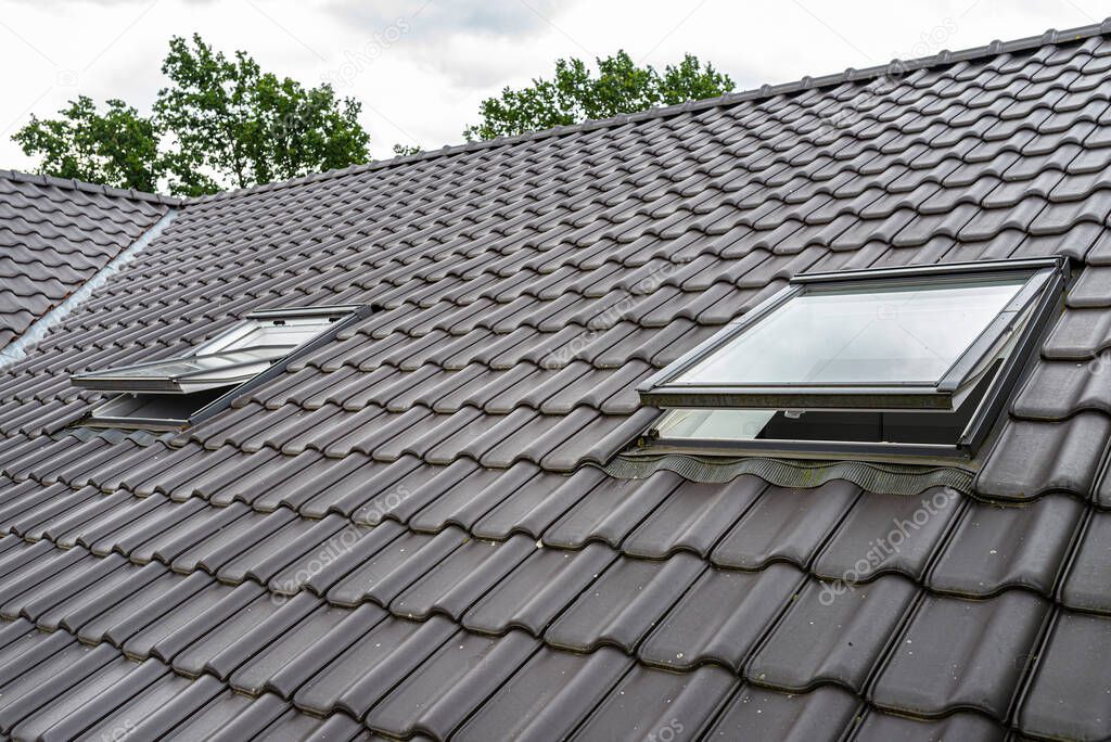 Two open roof windows in the attic, visible anthracite ceramic tiles.