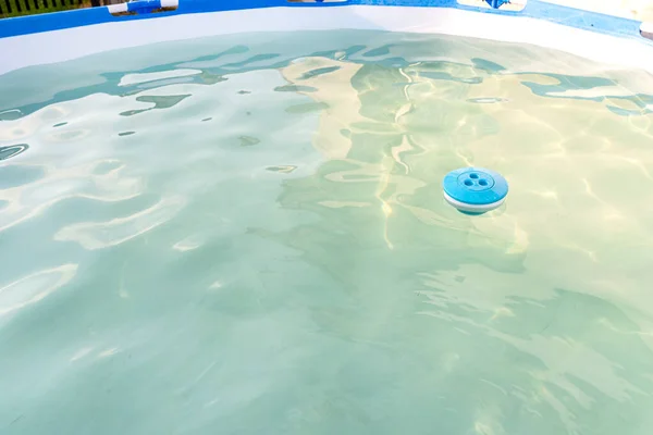 庭のホームプールに浮かぶ青塩素ディスペンサー 国内プールの掃除とケア — ストック写真