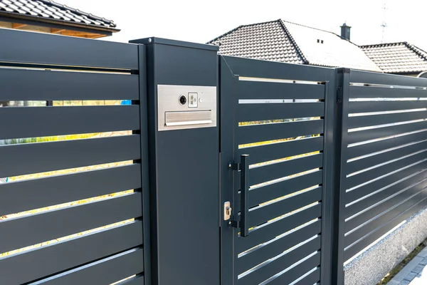 Posta kutusu ve kablosuz kart okuyucusu olan modern bir video fişi antrakt renginde çitlere monte edilmiş, görünür bir kale..