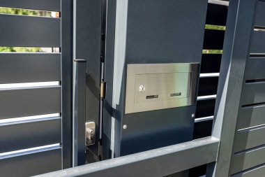 Modern bir panel çitinde kapalı kale antrasit rengi, görünür posta kutusu ve mandal..
