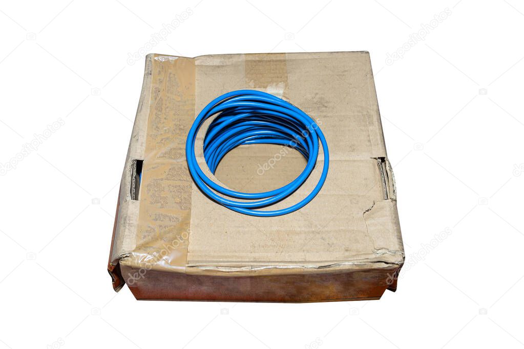 Blue electric cable sticking out of cardboard box, isolated on a white background with a clipping path.