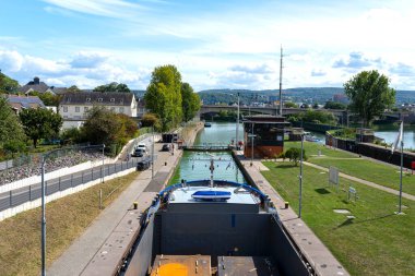 Kalın metal levhalarla dolu çifte mavna nehir kilidine akıyor..