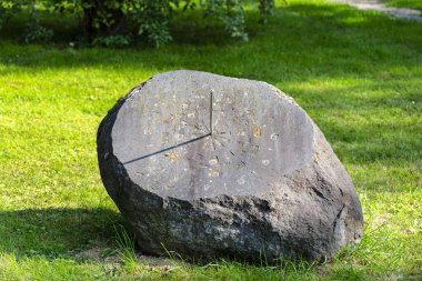 Metal çubuklu büyük bir taştan yapılmış eski bir güneş saati, saat 16: 00 'da başlayacak..