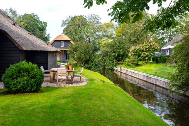 Giethoorn, Hollanda - 13 Eylül 2020. Hollanda 'nın ünlü Giethoorn köyünde su kanalları olan sazdan yapılmış güzel binalar. Köye Hollanda 'nın Venedik' i denir..