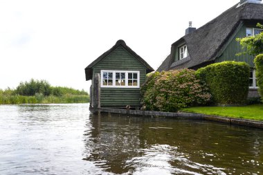 Giethoorn, Hollanda - 13 Eylül 2020. Hollanda 'nın ünlü Giethoorn köyünde su kanalları olan sazdan yapılmış güzel binalar. Köye Hollanda 'nın Venedik' i denir..