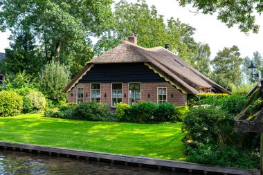 Giethoorn, Hollanda - 13 Eylül 2020. Hollanda 'nın ünlü Giethoorn köyünde su kanalları olan sazdan yapılmış güzel binalar. Köye Hollanda 'nın Venedik' i denir..