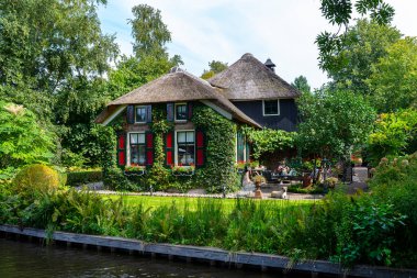 Giethoorn, Hollanda - 13 Eylül 2020. Hollanda 'nın ünlü Giethoorn köyünde su kanalları olan sazdan yapılmış güzel binalar. Köye Hollanda 'nın Venedik' i denir..