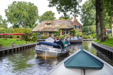 Giethoorn, Hollanda - 13 Eylül 2020. Ünlü Giethoorn köyündeki evlerin arasındaki kanalda yüzen turist teknesinden görüntü. Köy Hollanda 'nın Venedik' idir..