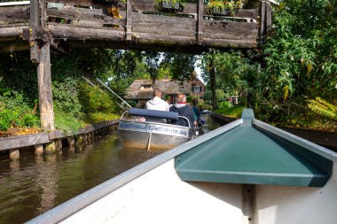 Giethoorn, Hollanda - 13 Eylül 2020. Ünlü Giethoorn köyündeki evlerin arasındaki kanalda yüzen turist teknesinden görüntü. Köy Hollanda 'nın Venedik' idir..