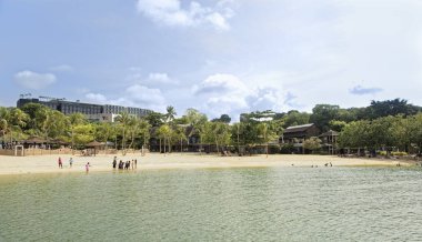  Singapore, Singapur-10 Ağustos 2018: Sentosa Palawan Plajı görünümünü. Kıyıda oturan insanlar