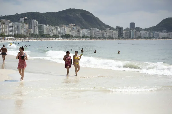 Ciudadanos nadando en el océano y caminando por Copacabana bea — Foto de Stock