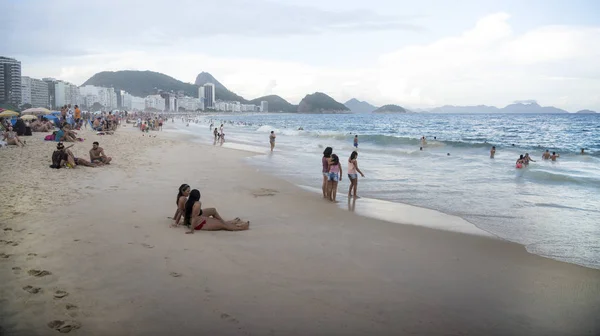 Cittadini che nuotano nell'oceano e camminano lungo Copacabana bea — Foto Stock