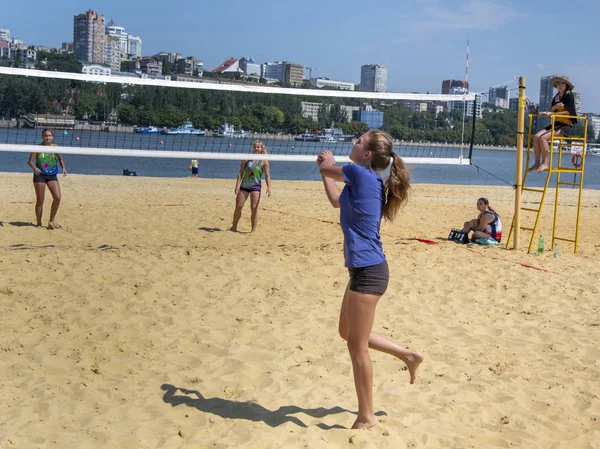 Leuke meiden spelen beachvolleybal. Vrienden kijken naar het spel. — Stockfoto