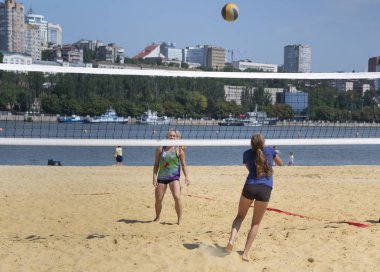  Sevimli kızlar plaj voleybolu oynar. Arkadaşlar oyunu izleyin.