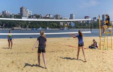  Sevimli kızlar plaj voleybolu oynar. Arkadaşlar oyunu izleyin.