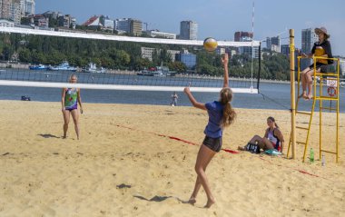  Sevimli kızlar plaj voleybolu oynar. Arkadaşlar oyunu izleyin.