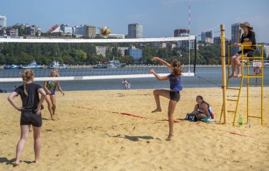   Sevimli kızlar plaj voleybolu oynar. Arkadaşlar oyunu izleyin.