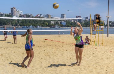   Sevimli kızlar plaj voleybolu oynar. Arkadaşlar oyunu izleyin.