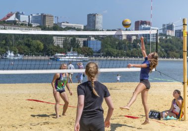   Sevimli kızlar plaj voleybolu oynar. Arkadaşlar oyunu izleyin.