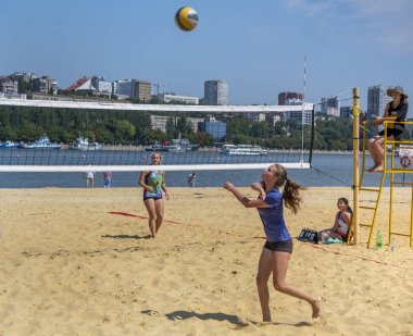  Sevimli kızlar plaj voleybolu oynar. Arkadaşlar oyunu izleyin.