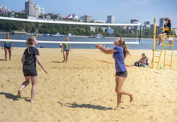 Leuke meiden spelen beachvolleybal. Vrienden kijken naar het spel. — Stockfoto