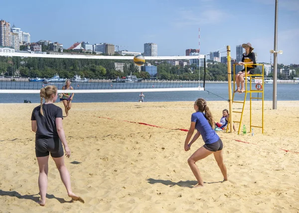 Leuke meiden spelen beachvolleybal. Vrienden kijken naar het spel. — Stockfoto