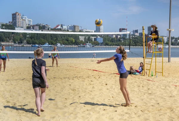 Leuke meiden spelen beachvolleybal. Vrienden kijken naar het spel. — Stockfoto