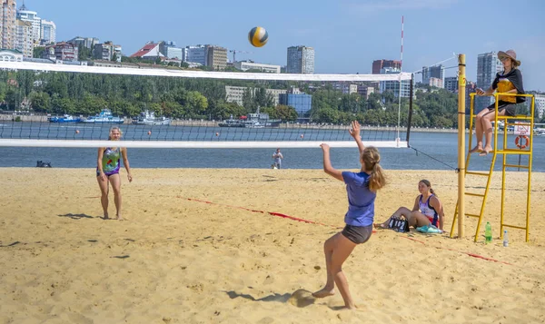 Leuke meiden spelen beachvolleybal. Vrienden kijken naar het spel. — Stockfoto