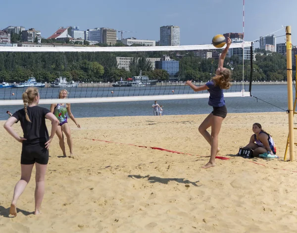 Leuke meiden spelen beachvolleybal. Vrienden kijken naar het spel. — Stockfoto