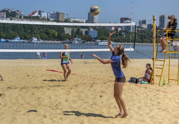 Leuke meiden spelen beachvolleybal. Vrienden kijken naar het spel. — Stockfoto