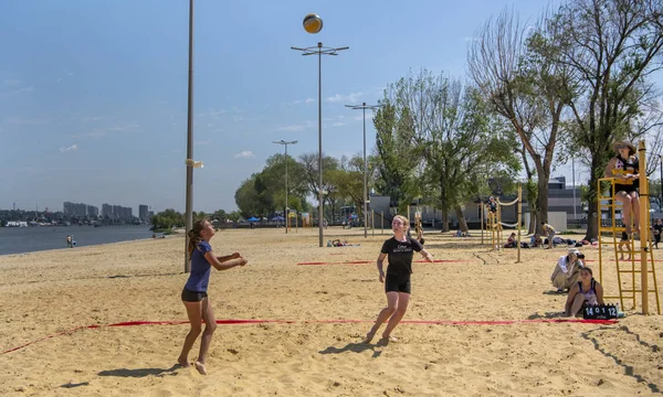 Leuke meiden spelen beachvolleybal. Vrienden kijken naar het spel. — Stockfoto