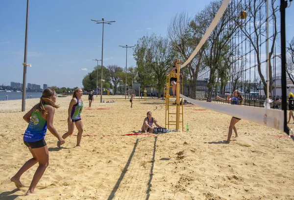 Leuke meiden spelen beachvolleybal. Vrienden kijken naar het spel. — Stockfoto