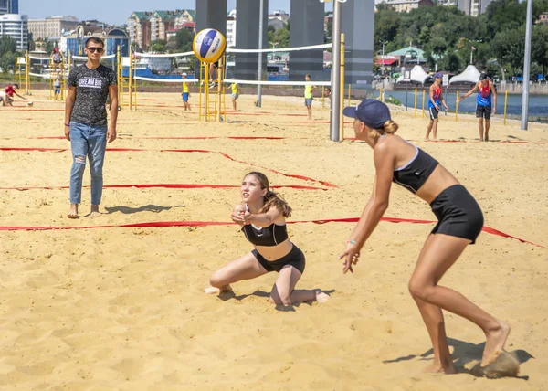 Meninas bonitos jogar vôlei de praia. Amigos assistem o jogo . — Fotografia de Stock