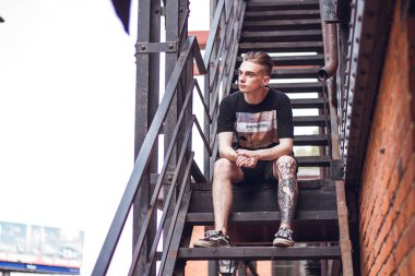 Adam dışarıda rahatlatıcı. Kıvırcık saçlı ofis, dışarıda seni bekleyen merdivenlerde oturan.