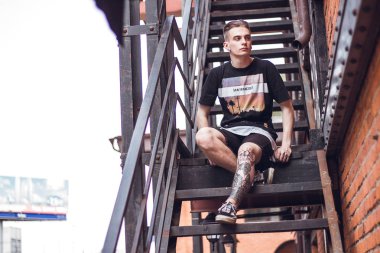 Adam dışarıda rahatlatıcı. Kıvırcık saçlı ofis, dışarıda seni bekleyen merdivenlerde oturan.