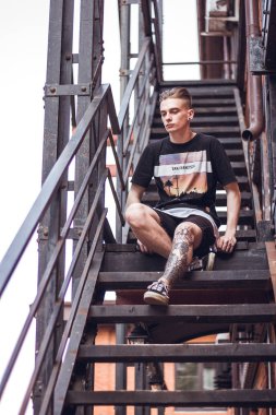 Adam dışarıda rahatlatıcı. Kıvırcık saçlı ofis, dışarıda seni bekleyen merdivenlerde oturan.