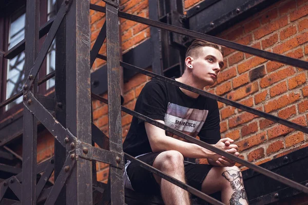 Adam dışarıda rahatlatıcı. Kıvırcık saçlı ofis, dışarıda seni bekleyen merdivenlerde oturan.