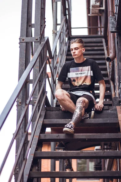 Adam dışarıda rahatlatıcı. Kıvırcık saçlı ofis, dışarıda seni bekleyen merdivenlerde oturan.