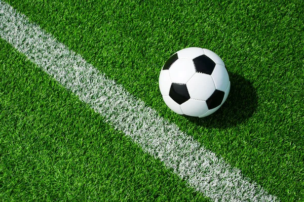 futbol topu siyah ve beyaz çizgili yeşil çimenlerin üzerinde