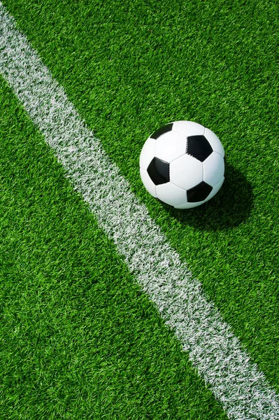 soccer ball black and white on green grass with lines